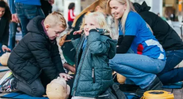 Kinderen-nemen-deel-aan-de-miniworkshop-leren-reanimeren-met-een-AED